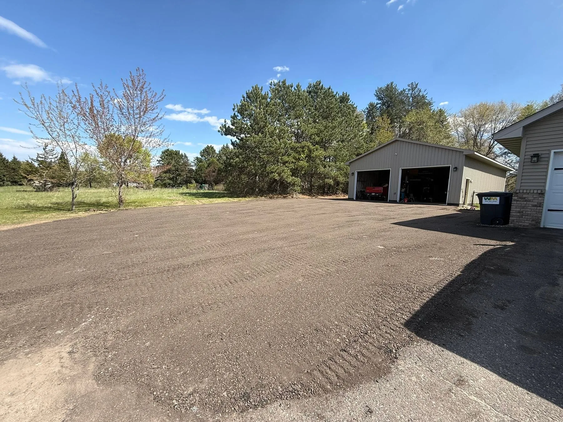 Freshly graded gravel driveway and open yard