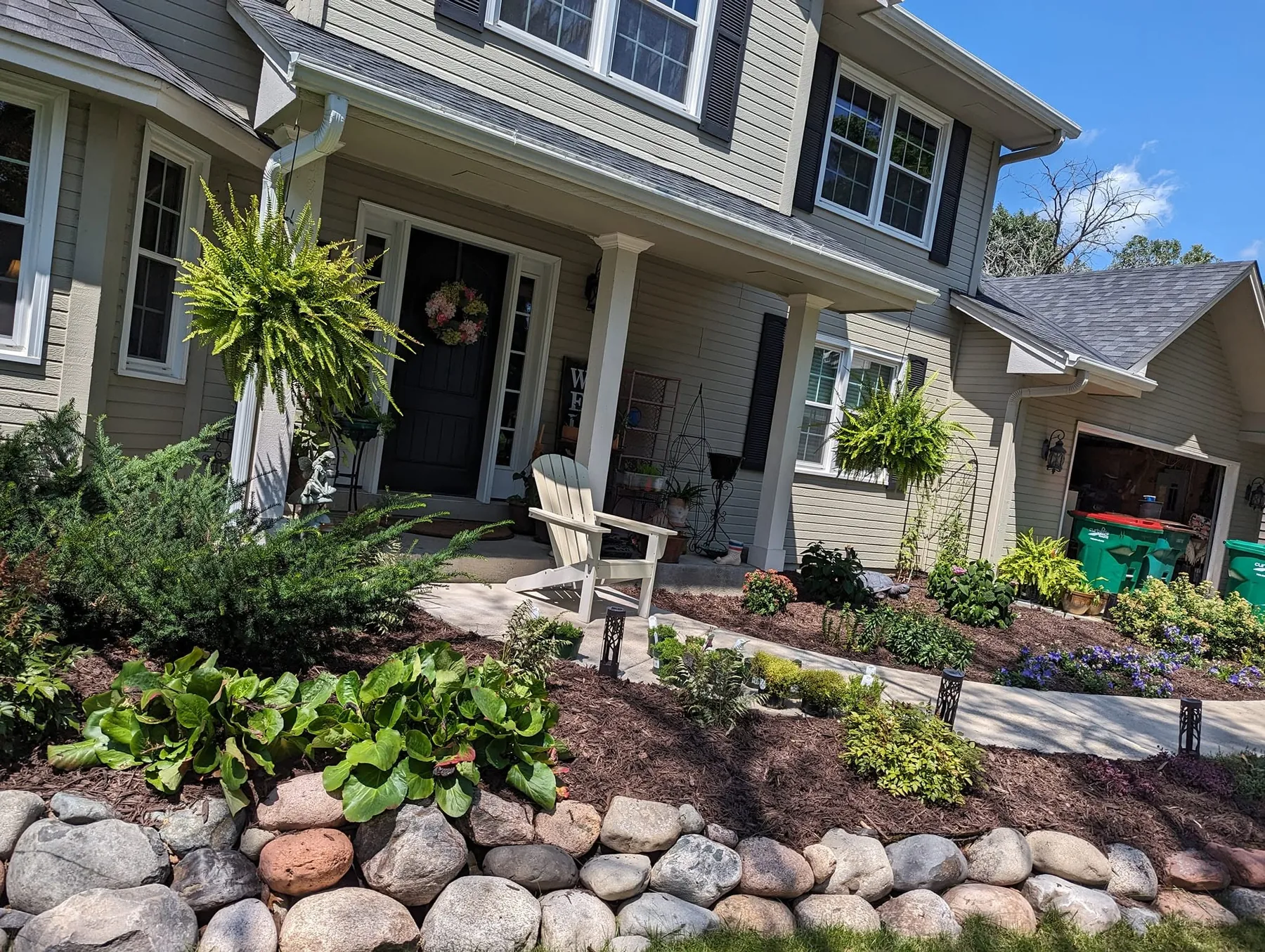 Finished garden beds and natural stone landscaping around a Minnesota home